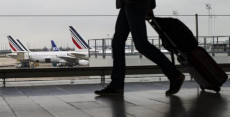 Un passeggero passa davanti alla vetrata dell'aeroporto Charles de Gaulle Roissy, fuori Parigi.