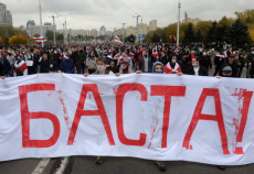 Manifestanti portano uno striscione con la scritta "Basta" in una strada di Minsk,