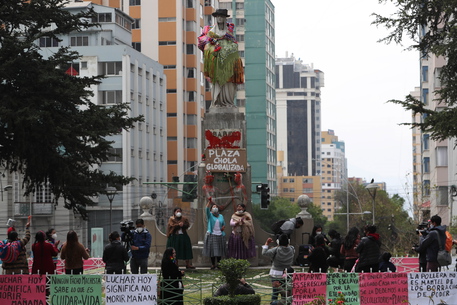 Un gruppo di manifestanti donne veste la statua di Isabella la Cattolica como una "Chola", (donna indigena aymara" a La Paz, Bolivia,
