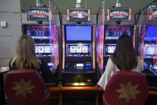 Persone giocando con le slot machine in un casinò.
