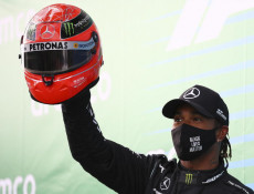 Lewis Hamilton sul podio del Nuerburgring alza al cielo il casco di Michael Schumacher.Archivio.