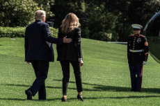 Il presidente Donald J. Trump e la First lady Melania Trump di spalle mentre camminano sul prato della Casa Bianca.