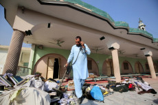 Un agente di sicurezza pakistano inspecciona la scena dell'esplosione a Peshawar, Pakistan.