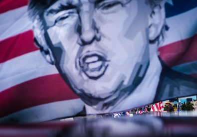 Una bandiera a strisce e stelle con l'immagine di Donald Trump sventola in un comizio del presidente americano nel Nevada.