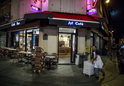 Un cameriere raccoglie i tavoli in un caffé di Parigi.
