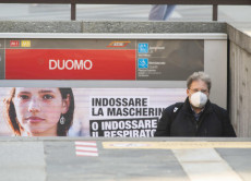 Persone con le mascherine alla fermata della metro Duomo a Milano