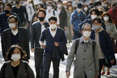 Giapponesi in strada con mascherine a Tokyo.