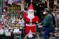 Passanti in mascherina anti covid avanti ad un negozio di articoli di Natale nel centro storico di Napoli