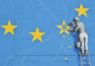 Un operaio toglie una stella alla bandiera dell'Unione Europea con uno scalpello, in un'illustrazione sul Brexit.