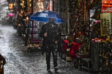 Ombrelli riparano dalla pioggia i pochi visitatori di San Gregorio Armeno, strada del centro storico di Napoli che ospita le botteghe degli artigiani del presepe