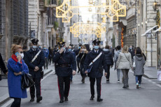 Agenti delle forze dell'ordine, con i volti coperti da mascherine, effettuano controlli anti assembramenti nelle vie del centro storico durante lo shopping natalizio, Roma