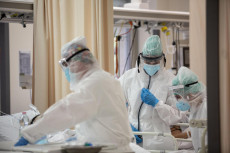 Operatori sanitari, che indossano tute protettive mediche e mascherine, al lavoro nella terapia intensiva dell'Ospedale Sant'Orsola di Bologna,