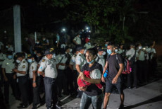 Migranti honduregni passano davanti a un posto di blocco della polizia al confine di Honduras e Guatemala.