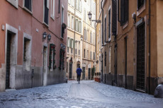 Uno sportivo solitario facendo jogging in una strada di Trastevere a Roma.