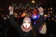 Una manifestante mostra la mascherina con il fulmine, simbolo del movimento femminile di sciopero, di fronte alla corte costituzionale di Varsovia.