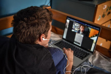 Studente a casa segue le lezioni di scuola con la DAD (didattica a distanza) usando il computer,