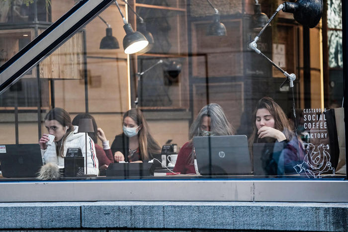 Studenti in un caffè a Torino seguono le lezioni in wifi.