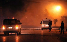 Agenti di sicurezza di Tunisia vigilano una strada dopo gli scontri con manifestanti., in Ettadhamen, Tunisia,