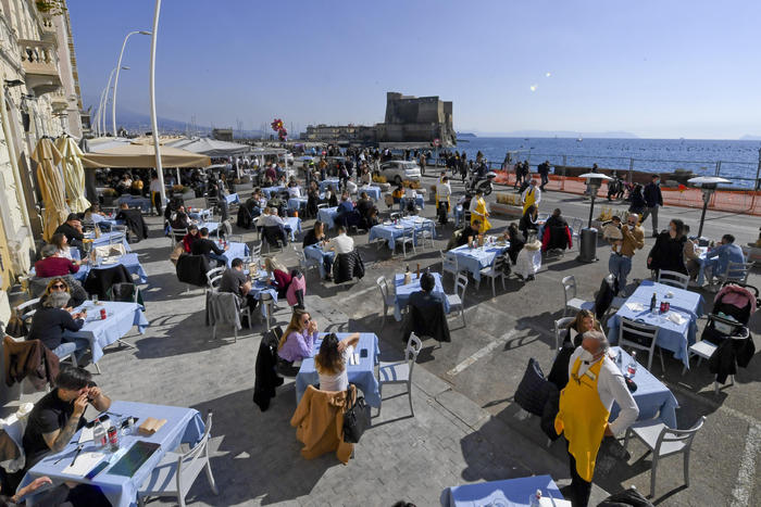 Un affollato ristorante sul lungomare di Napoli durante il fine settimana.