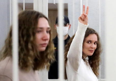La giornalista Katerina Bakhvalova fa il cenno della vittoria accanto alla sua collega Daria Chultsova dentro una carcere in Minsk.