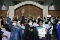 Studenti dell'Universitá di Dagon fanno il segnale delle tre dita. simbolo del movimiento di disobbedienza in protesta contro il golpe dei militari in Yangon, Birmania.
