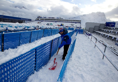 Un operatore spazza la neve in una pista di Cortina:
