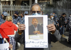 Un manifestante mostra un cartello con la foto dell intelletuale e attivista Lokman Slim.