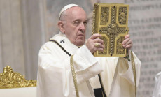 In una foto d'archivio Papa Francesco mostra il Vangelo durante la Messa.