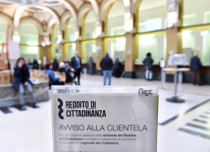Cartello sul reddito di cittadinanza presso l'ufficio postale centrale in via Alfieri, Torino,