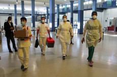 Operatori sanitari indossano tute e mascherine protettive per effettuare controlli su 215 passeggeri bangladesi del volo speciale della Biman Bangladesh Airlines (Bg4165) appena arrivato a Fiumicino da Dacca, Roma
