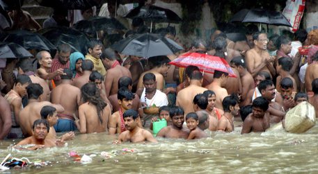 Una folla si bagna nel Gange.