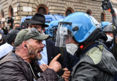 Un manifestante discute con nun poliziotto duyrante la protesta dei commercianti a Roma.