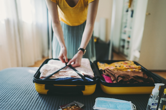Una donna prepara la valigia: voglia di viaggiare.
