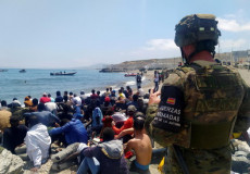 Soldati dell'esercito spagnolo sorveglia un gruppo di migranti a Ceuta: