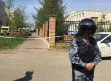 Un poliziotto russo davanti alla scuola presa d'assalto a Kazan in Russia.