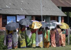 Una fila di donne con l'ombrello in India.