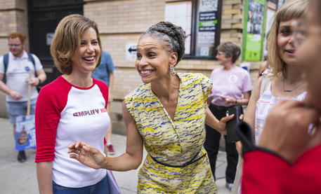 La candidata a sindaco di New York Maya Wiley (C) tparla con votanti nella strada.