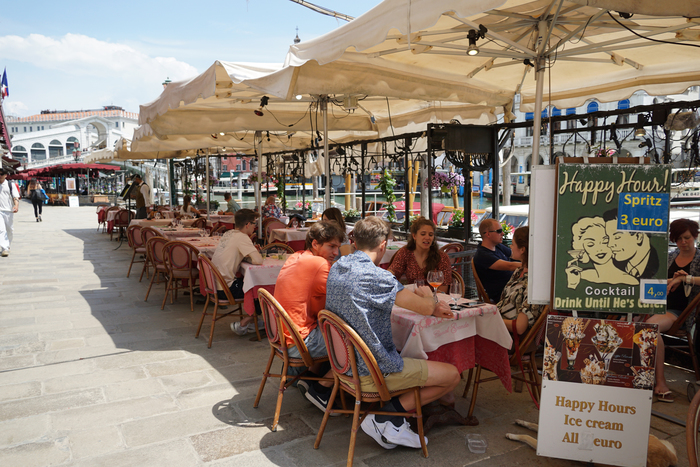 Pochi turisti ai tavoli dei ristoranti sulla riva del Vin, a Rialto.