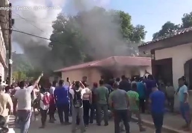 Una folla circonda la casa di Giorgio Scanu in Santa Ana de Yusguare, Honduras.