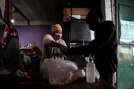 Un uomo riceve del cibo in una mensa comunitaria a Buenos Aires