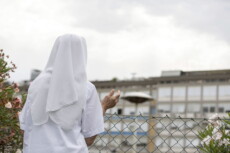 Una suora prega per la salute di Papa Francesco rivolta alla finestre dove è ricoverato al Policlinico Gemelli..
