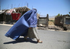 Una donna afghana coperta con il burqa, velo e tunica