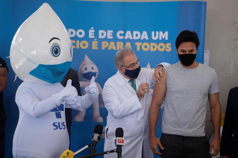 Il ministro brasiliano della Salute Marcelo Queiroga (C), inietta una dosi di vaccino anticovid-19 al ministro delle comunicazioni durante Fabio Farias (R), durante una giornata di vaccinazione in Brasile. ANSA/ EPA/Joedson Alves