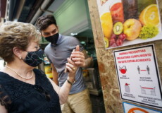 Una signora scatta una foto ad un cartello con le regole anticovid d'ingresso a un locale in Galizia, Spagna.