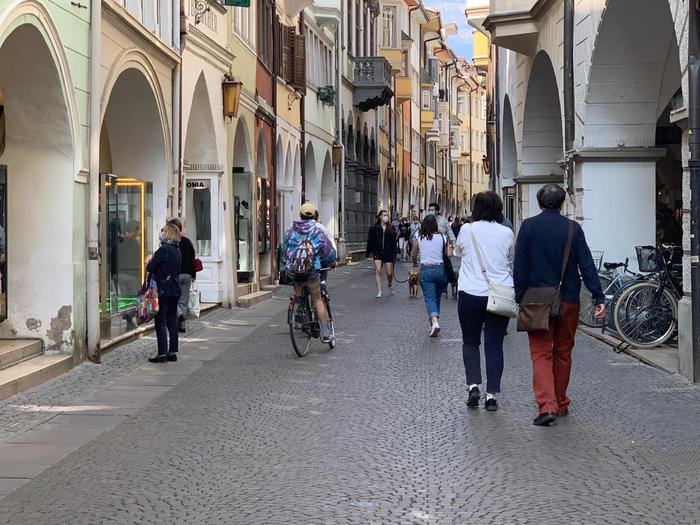 In una foto d'archivio cittadini con mascherina passeggiano in una via centrale a Bolzano.
