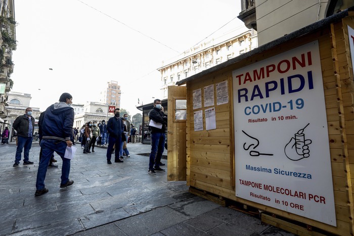 Diverse persone in coda per fare il test del tampone rapido covid 19 davanti ad una farmacia in porta Venezia a Milano