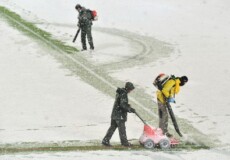 Addetti ai lavorispazzano la neve nello stadio di Bergamo.