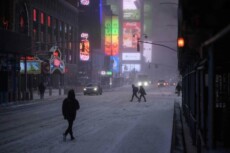 Pedoni ed auto in transito a Times square, New York, sotto la tempesta di neve