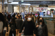 Gente con le mascherine protettive in un centro commerciale.