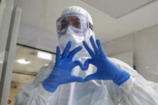 Un sanitario dell'ospedale Bio-Chimico di Roma fa il segno del cuore.